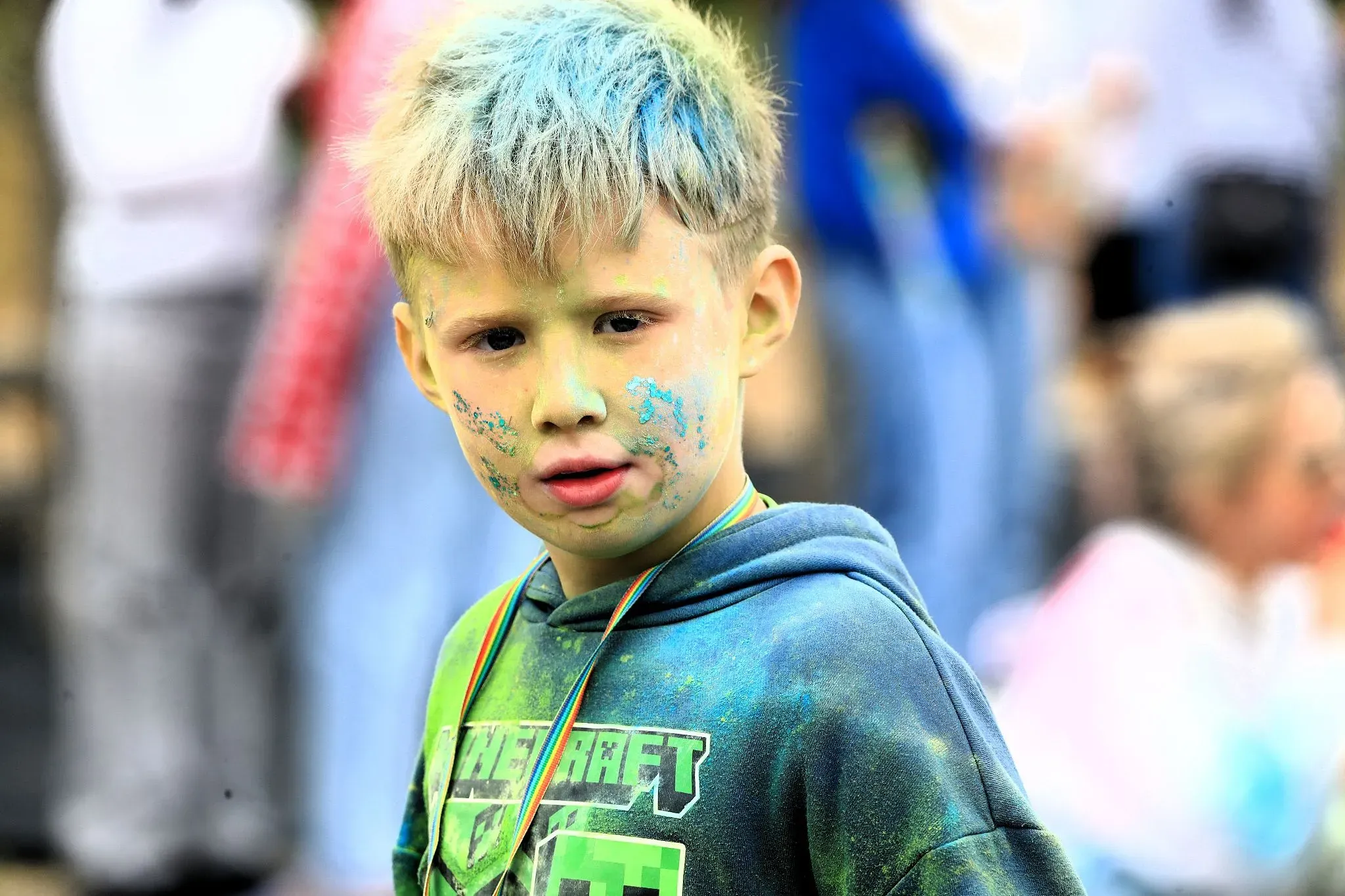 Child covered in colourful paint powder at a family paint event